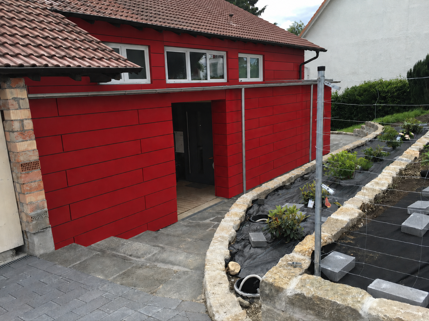 Kunstvolle Spenglerarbeiten und moderne Metallfassade in Rot